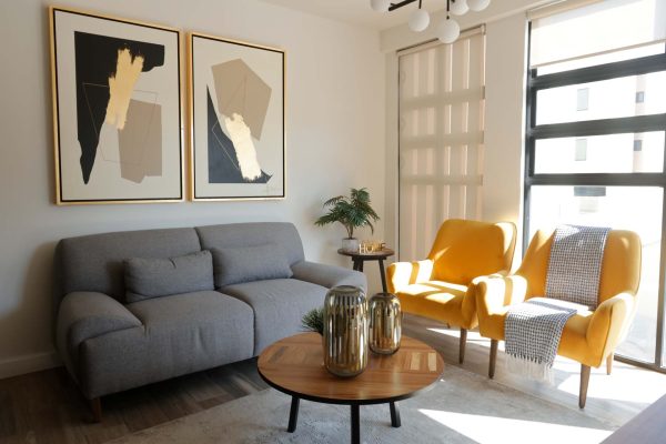 Un salón con dos sillas amarillas y una mesa de centro Privada Cobalto.